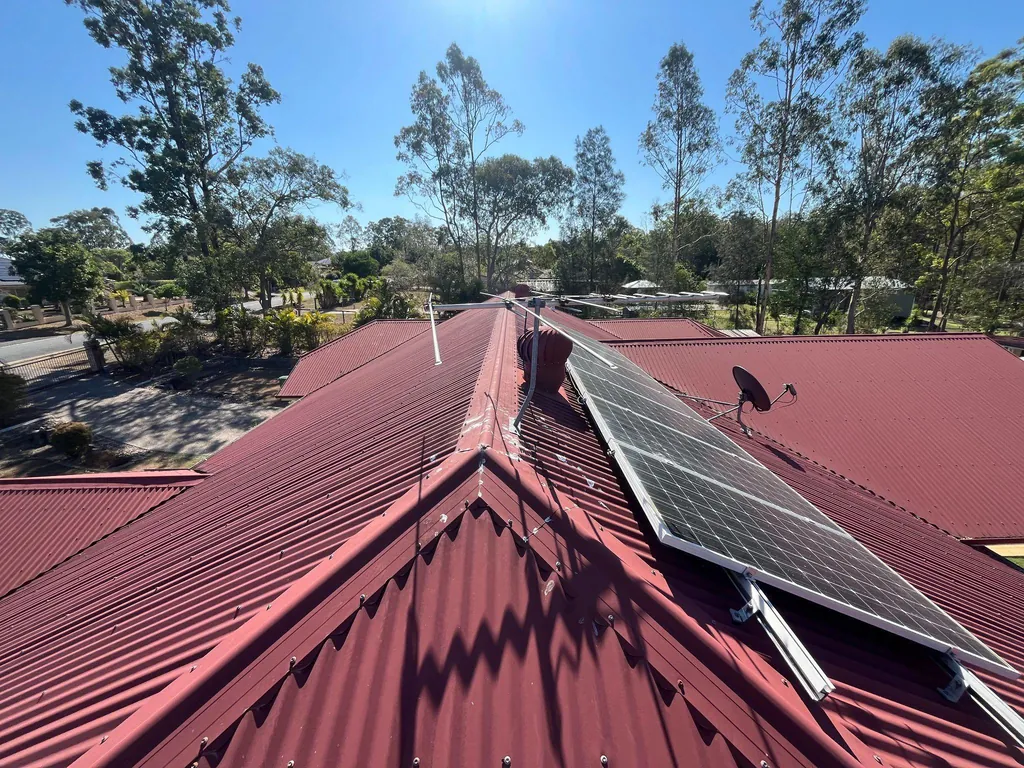 Before: ageing red metal roof with solar panels